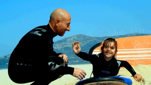 instructor ensenando a una nina las tecnicas del surf
